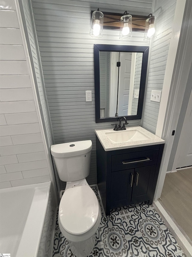 bathroom with vanity, wood walls, and toilet