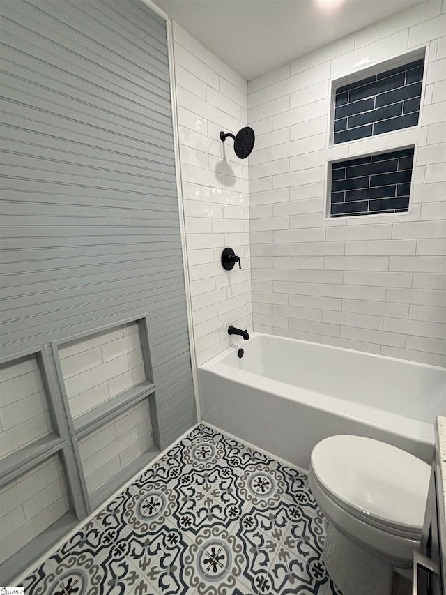 bathroom with tile patterned floors, tiled shower / bath, and toilet