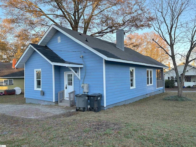 rear view of house featuring a lawn