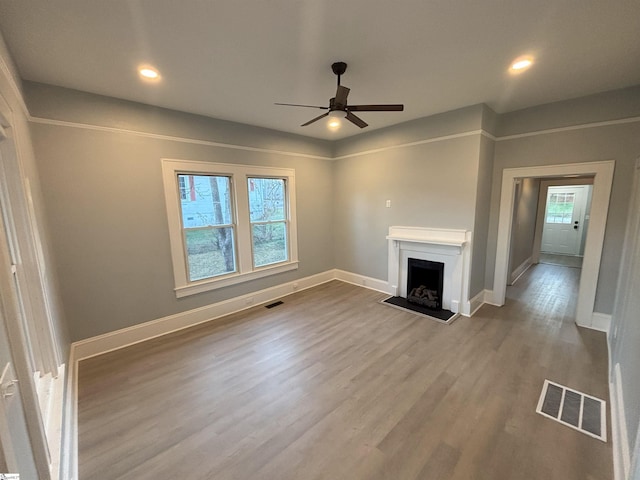 unfurnished living room with light wood-type flooring and ceiling fan