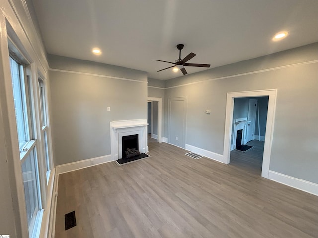 unfurnished living room featuring hardwood / wood-style flooring and ceiling fan