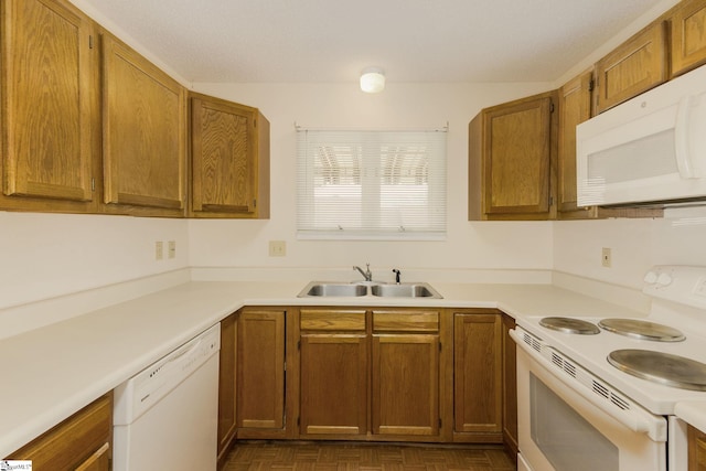 kitchen featuring dark parquet flooring, white appliances, and sink