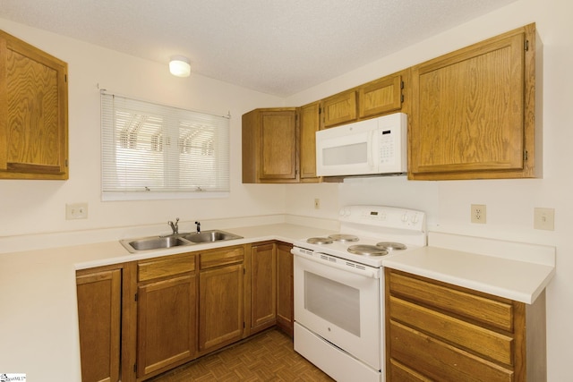 kitchen featuring a textured ceiling, dark parquet flooring, sink, and white appliances