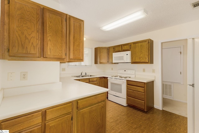 kitchen with a textured ceiling, dark parquet flooring, sink, and white appliances