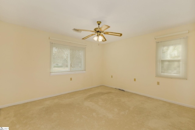 spare room with light carpet, ceiling fan, and a healthy amount of sunlight