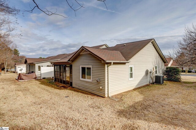 rear view of house featuring a yard, cooling unit, and a sunroom