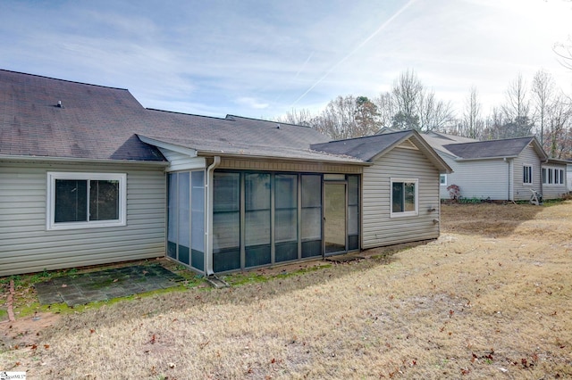 back of property featuring a sunroom and a yard