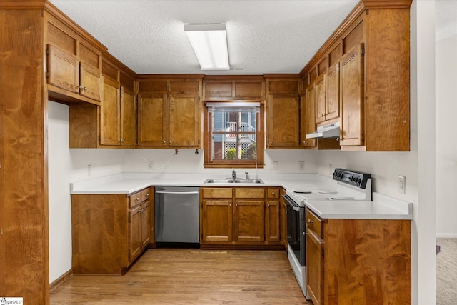 kitchen with under cabinet range hood, electric range, brown cabinets, and stainless steel dishwasher