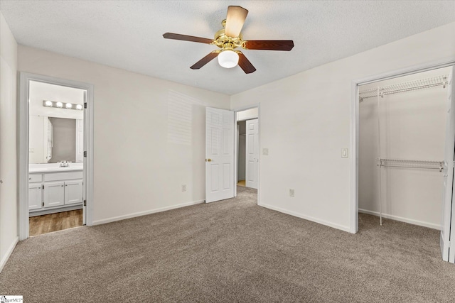 unfurnished bedroom featuring baseboards, carpet flooring, a closet, a textured ceiling, and a sink