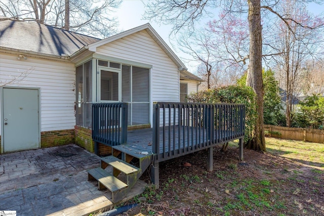 wooden deck with a patio area, fence, and a sunroom