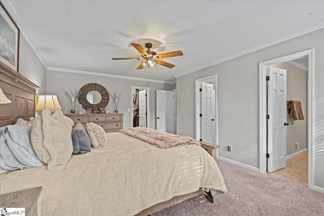 bedroom with a walk in closet, crown molding, ceiling fan, light colored carpet, and a closet