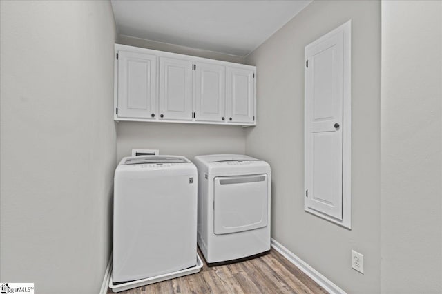 laundry area featuring light hardwood / wood-style floors, cabinets, and independent washer and dryer