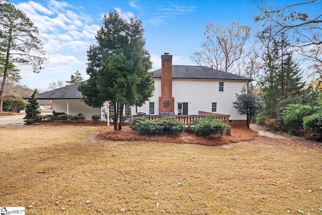 rear view of property featuring a yard and a wooden deck