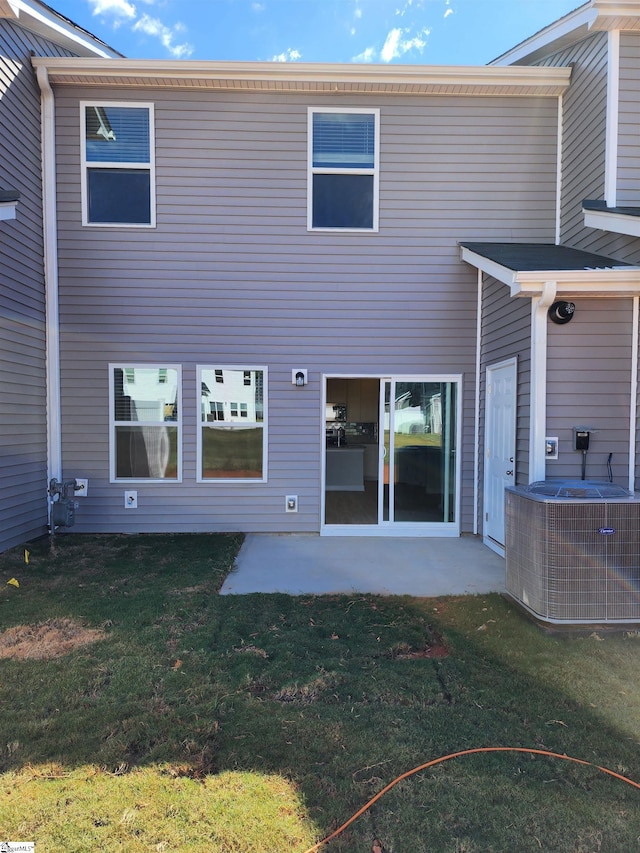 rear view of house with a patio area, a yard, and central AC