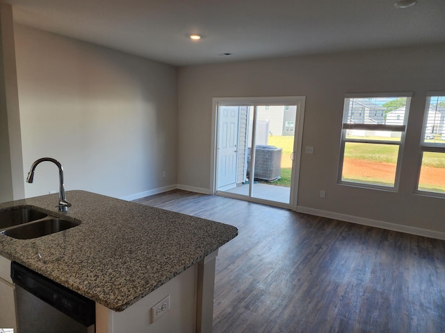 kitchen with white cabinets, sink, dark stone countertops, dishwasher, and dark hardwood / wood-style floors