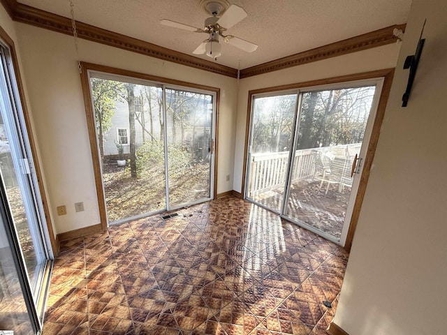 interior space with a ceiling fan, a healthy amount of sunlight, and visible vents