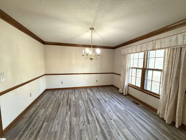 unfurnished dining area with a notable chandelier, baseboards, dark wood-style flooring, and a textured ceiling