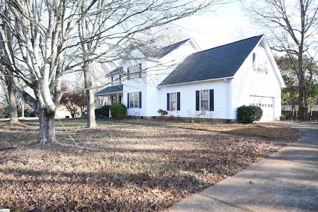 view of front of property featuring concrete driveway, an attached garage, and roof with shingles