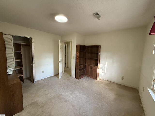 unfurnished bedroom with light carpet and a closet