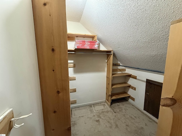 staircase with baseboards, lofted ceiling, a textured ceiling, and carpet flooring