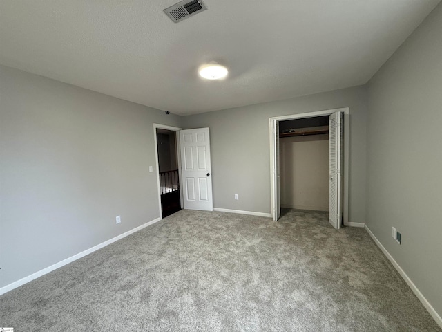 unfurnished bedroom with visible vents, baseboards, carpet, and a closet