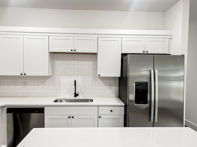 kitchen featuring backsplash, white cabinetry, sink, and appliances with stainless steel finishes