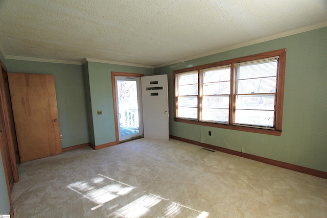 interior space with a textured ceiling, light colored carpet, and ornamental molding