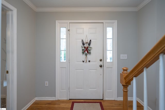 foyer featuring crown molding, wood-type flooring, and a textured ceiling