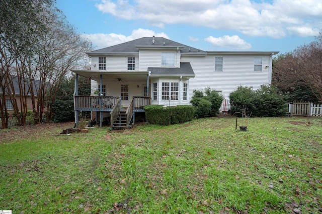 back of property featuring a deck and a lawn