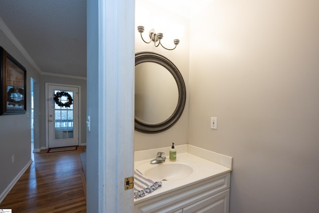 bathroom featuring wood-type flooring, vanity, and crown molding