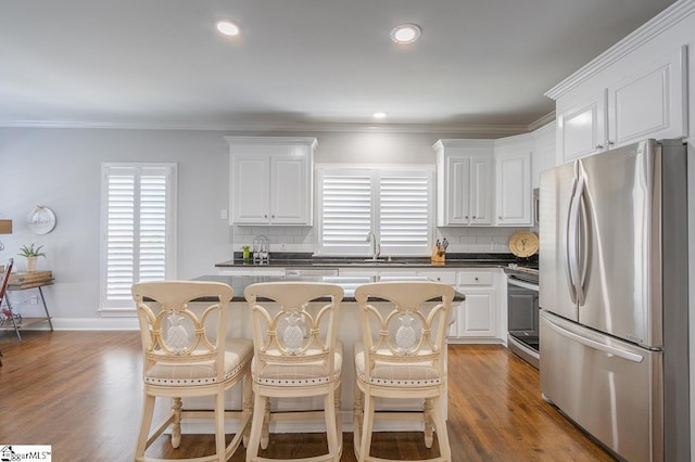 kitchen featuring backsplash, white cabinetry, a center island, and appliances with stainless steel finishes