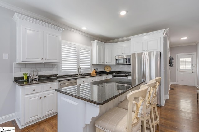 kitchen featuring white cabinets, a center island, dark wood-type flooring, and appliances with stainless steel finishes