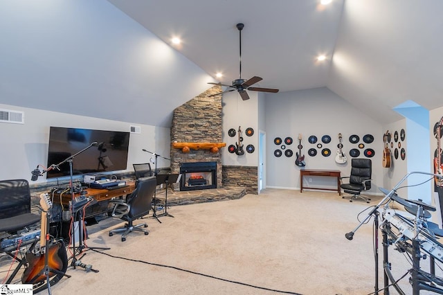 office space with carpet, vaulted ceiling, a stone fireplace, and ceiling fan