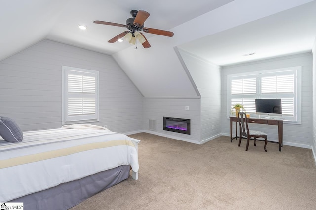 bedroom with light carpet, a fireplace, ceiling fan, and lofted ceiling