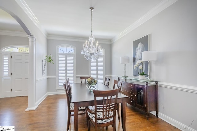 dining area with ornate columns, ornamental molding, and hardwood / wood-style flooring