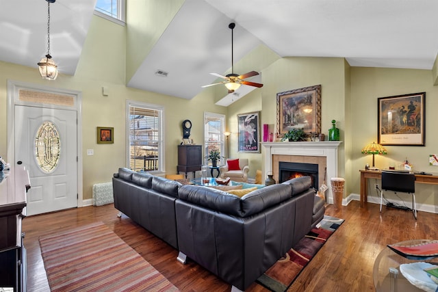 living room featuring a tile fireplace, lofted ceiling, ceiling fan, and dark hardwood / wood-style floors