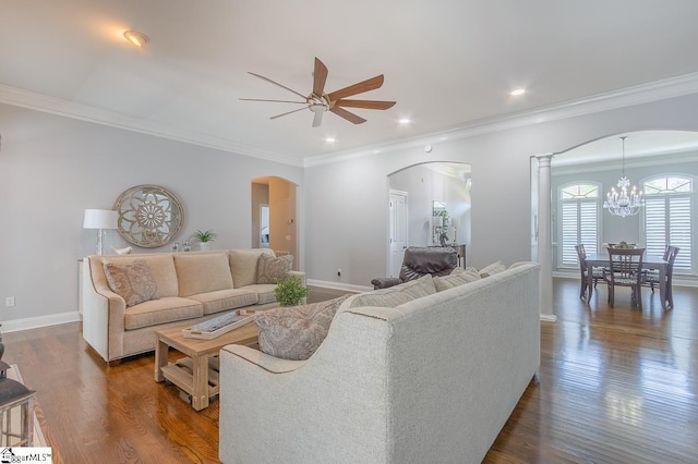 living room with crown molding, dark hardwood / wood-style flooring, and ceiling fan with notable chandelier