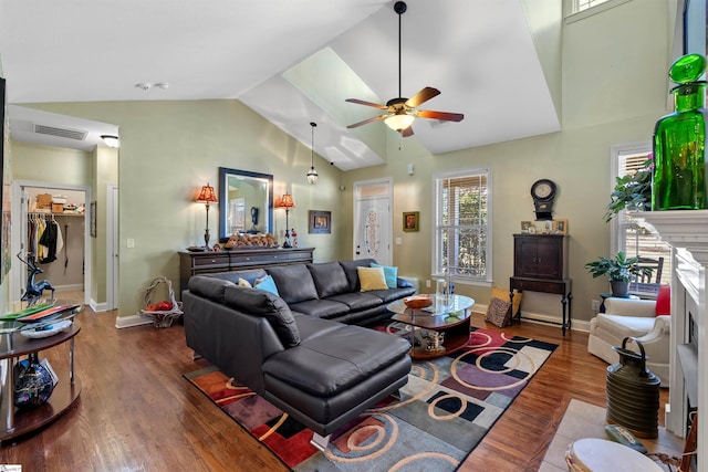 living room featuring ceiling fan, dark wood-type flooring, a fireplace, and vaulted ceiling