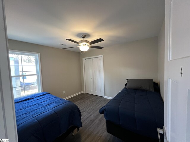 bedroom with dark hardwood / wood-style flooring, a closet, and ceiling fan