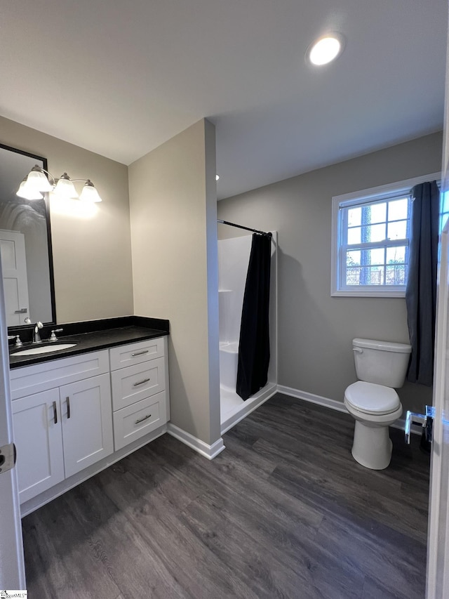 bathroom with a shower with curtain, toilet, vanity, and hardwood / wood-style flooring