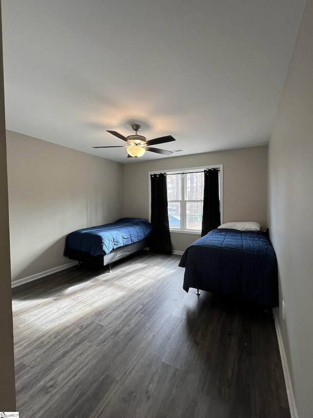 bedroom with ceiling fan and dark wood-type flooring