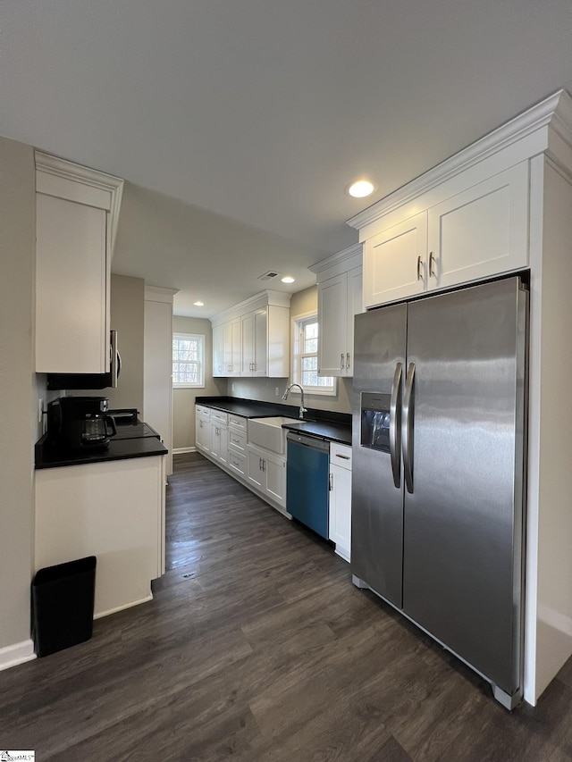 kitchen featuring white cabinets, appliances with stainless steel finishes, dark hardwood / wood-style floors, and sink