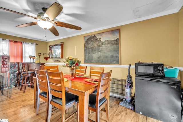 dining room featuring ceiling fan, light hardwood / wood-style floors, and ornamental molding