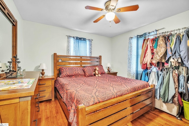 bedroom with ceiling fan, a closet, light wood-type flooring, and multiple windows