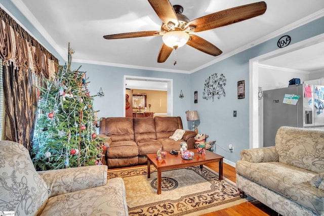 living room featuring hardwood / wood-style floors, ceiling fan, and crown molding