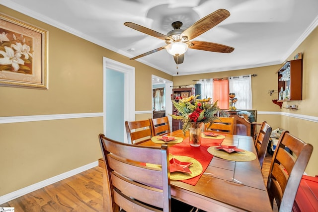 dining area featuring crown molding, ceiling fan, and light hardwood / wood-style floors