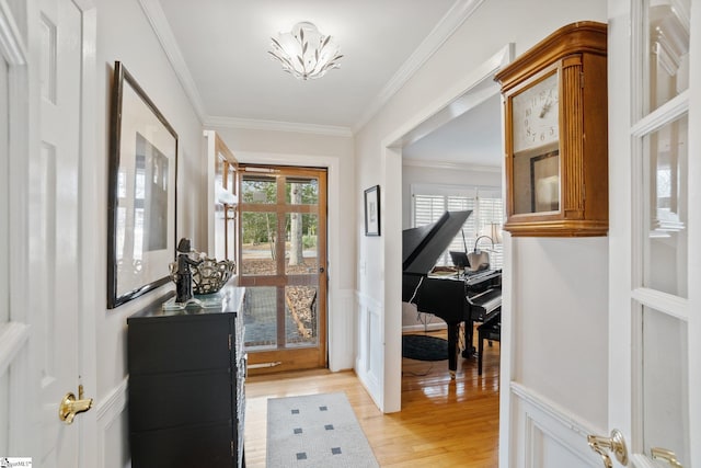 doorway to outside featuring ornamental molding, a chandelier, and light hardwood / wood-style flooring