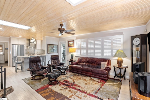 living room featuring ceiling fan, plenty of natural light, and wood ceiling