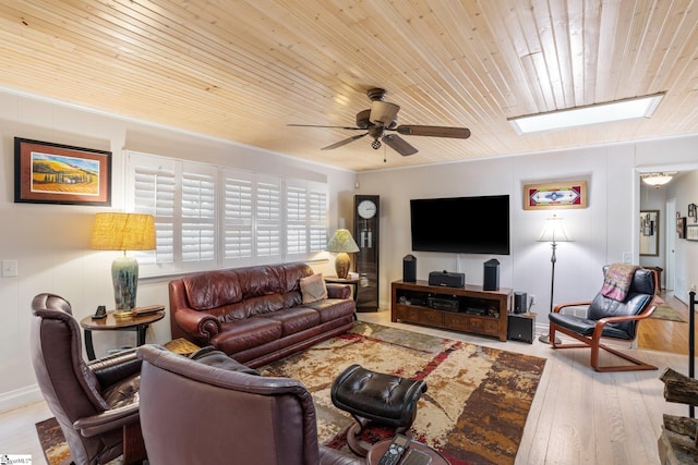 living room featuring wooden ceiling, a skylight, light hardwood / wood-style flooring, and ceiling fan