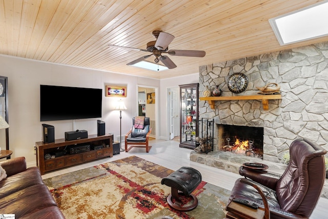 living room with ceiling fan, wood ceiling, crown molding, and a fireplace